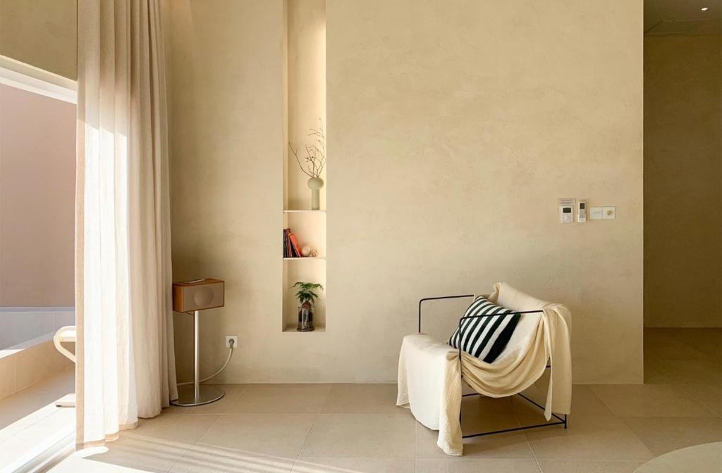 a living room with a white chair and a wall at 몽중정원 in Sinhŭng i-ri