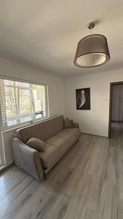 a living room with a couch and a large window at Lion Crib in Bacău