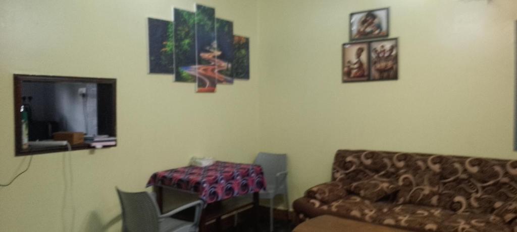 a living room with a couch and a table at Tenzi BnB in Jinja