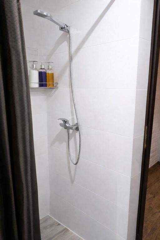 a shower with a shower head in a bathroom at Apart NOVA in Raszyn