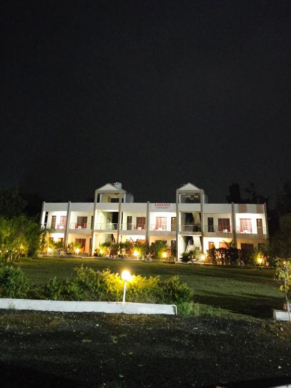 a large white building at night with lights at Camp Leo Aaranya Resort in Sasan Gir
