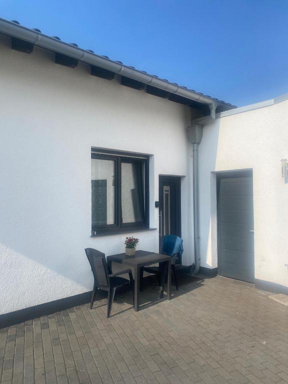 a patio with a table and chairs next to a building at Apartment in der Eifel in Blankenheim