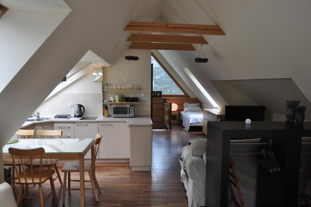 a kitchen and living room with a table and chairs at Willa Marma B&B in Zakopane