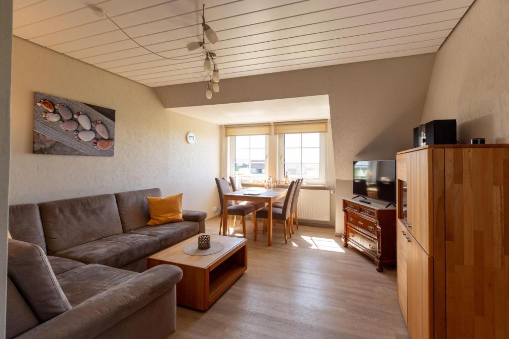 a living room with a couch and a table at Hus-Pellworm-2-Ferienwohnung-Meereswelle in Pellworm