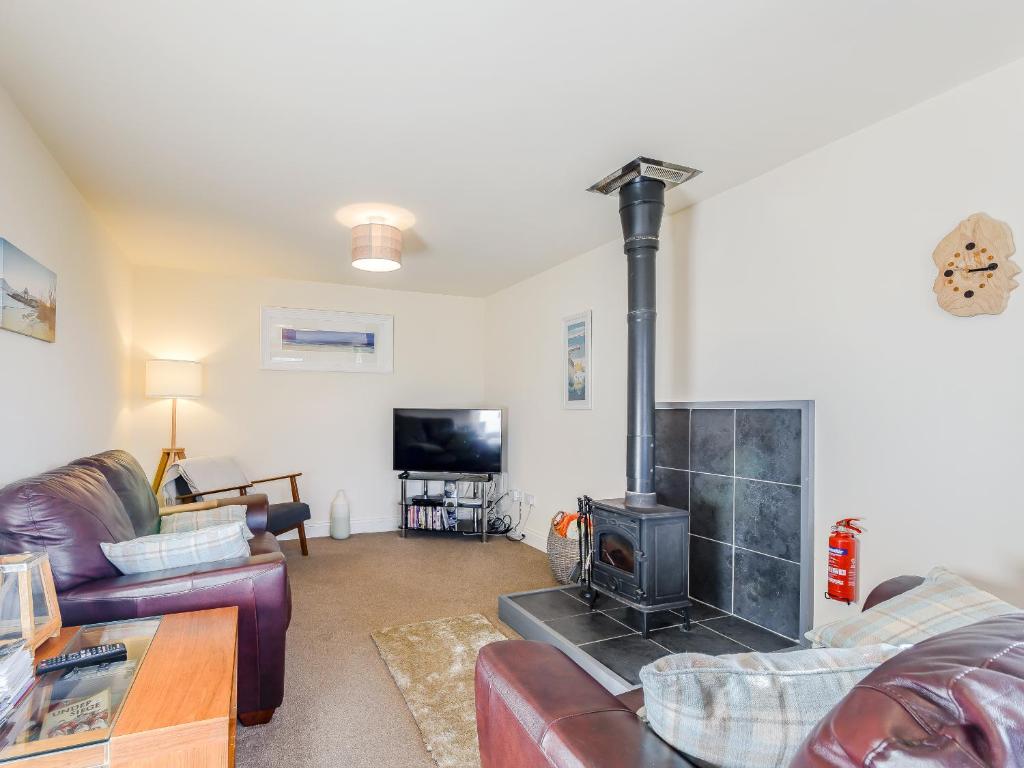 a living room with a couch and a fireplace at The Barn in Kilmory