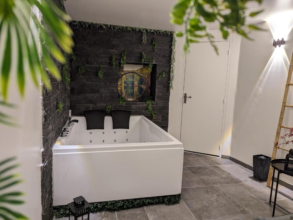 a white bath tub in a room with a brick wall at Cozy AM Spa and Cinema in Andance