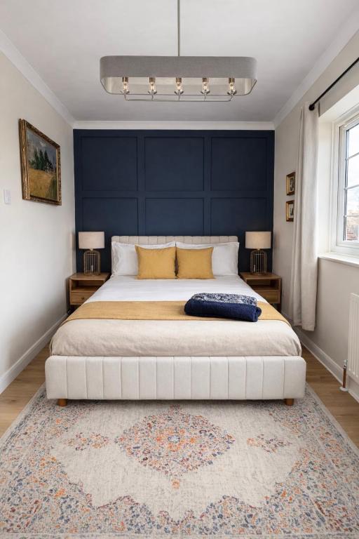 a bedroom with a large bed with a blue wall at Rossetti Retreat in Birchington