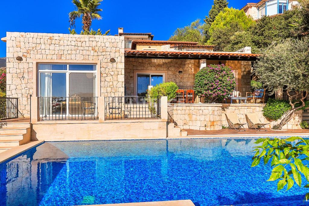 a house with a swimming pool in front of a house at TEKCE Villa Mae N3 in Yeniköy