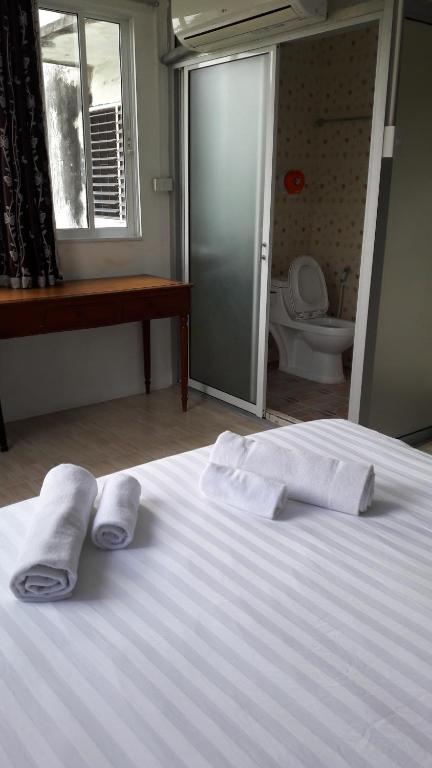 una camera da letto con un letto e asciugamani di Nong Guest House a Pattaya Sud