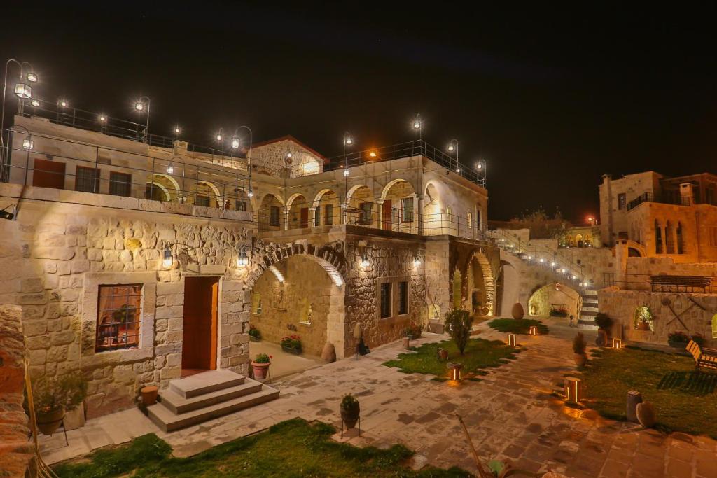 a large stone building with lights on it at night at Acropolis Cave Suite in Ürgüp