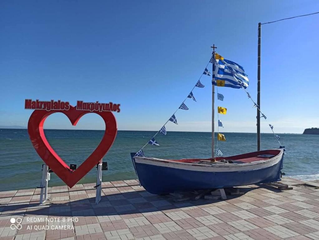 a boat with a heart sign next to the ocean at Rooms To Let Giannis in Makrygialos