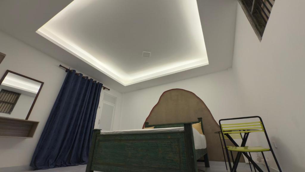 a room with a bed and a chair and a ceiling at SeekRide Bolgoda in Bandaragama