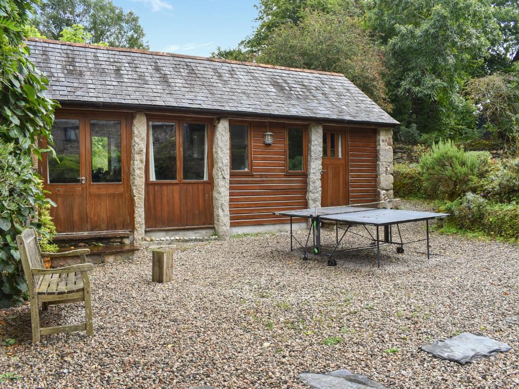 a picnic table in front of a cabin at Swallows Barn in Liskeard