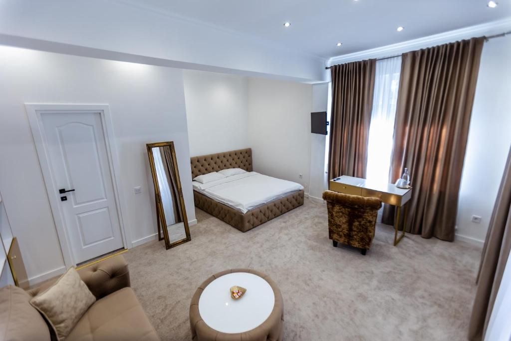 a living room with a bed and a mirror at Villa Jolie in Craiova