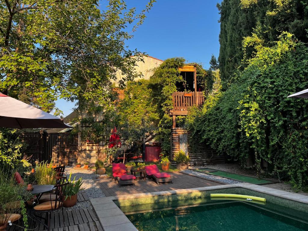 a backyard with a swimming pool and a patio with tables and chairs at Fundalucia Guesthouse in Quéntar