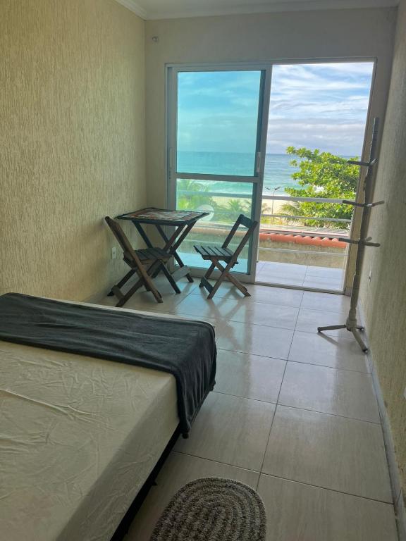 a bedroom with a bed and a view of the ocean at Surf Zone Hostel in Saquarema