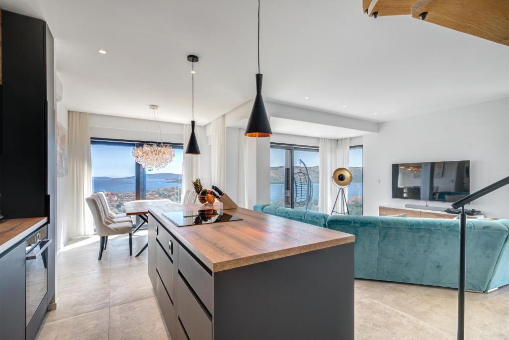 a kitchen and living room with a blue couch at Villa Luca in Seget Vranjica
