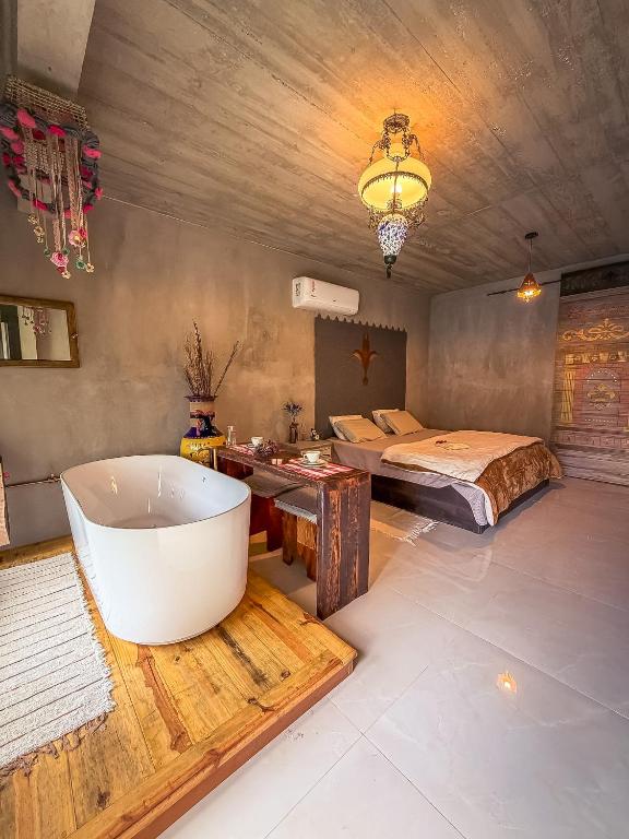a bathroom with a bath tub and a bed at Vila Carmen Imperial in Domingos Martins