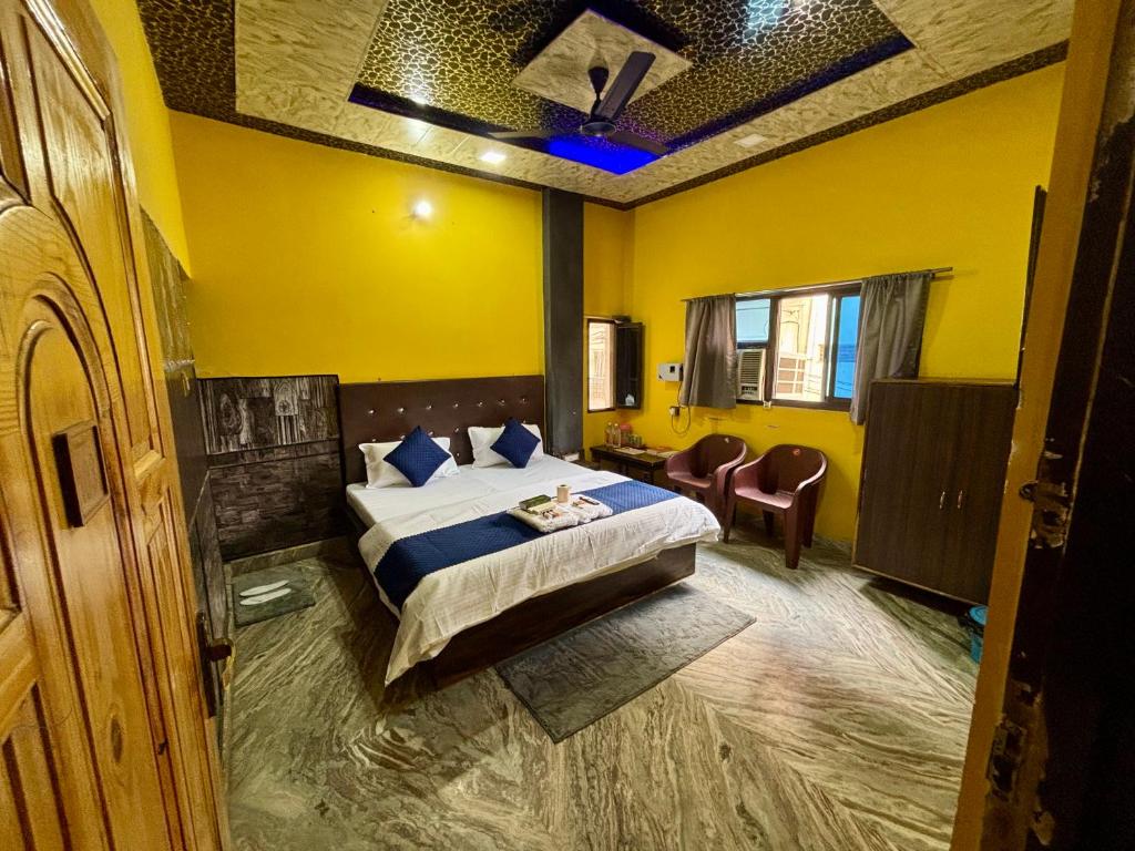 a bedroom with a bed in a yellow room at Amber Palace in Varanasi