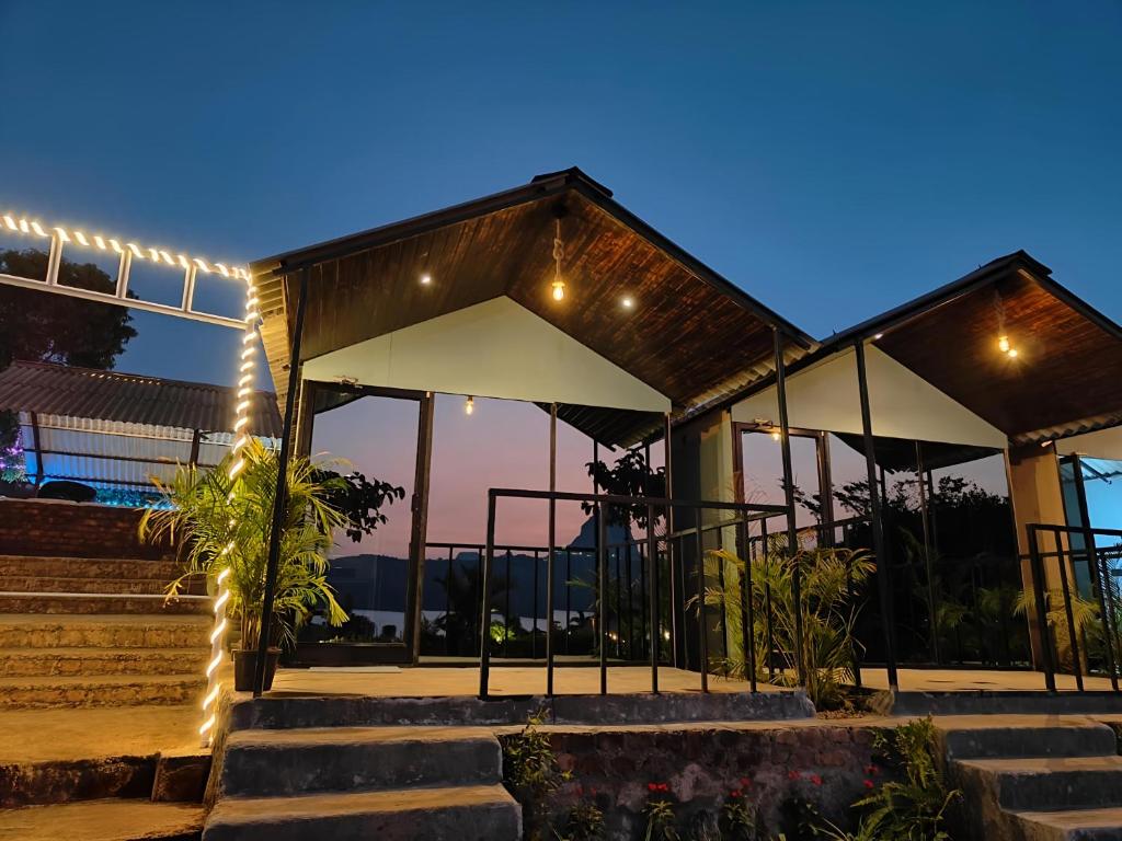a night view of a building with lights at Shelby Pawana lake Cottages and Camping in Lonavala
