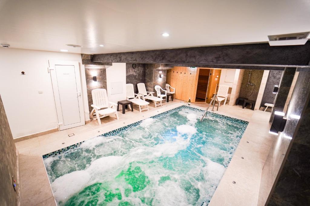 ein großer Swimmingpool mitten in einem Haus in der Unterkunft Urusossziklakert in Dealu