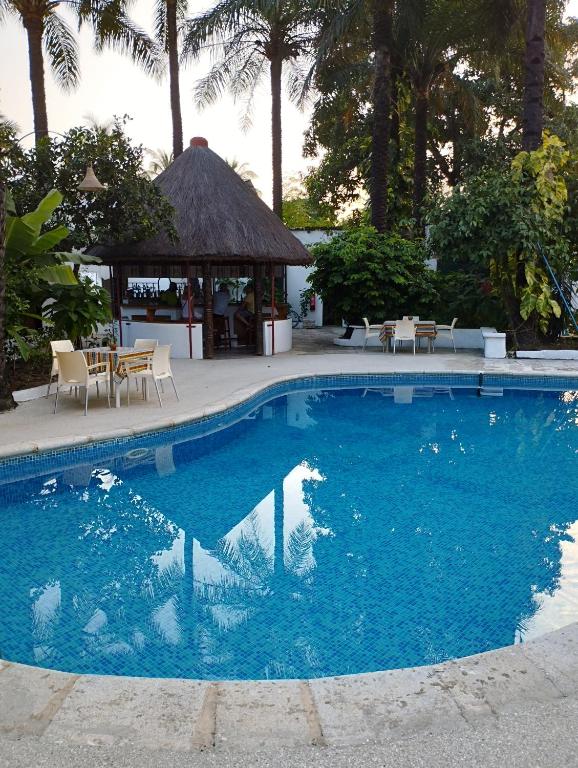a large blue swimming pool with a gazebo at BALAFON hôtel in Cap Skirring