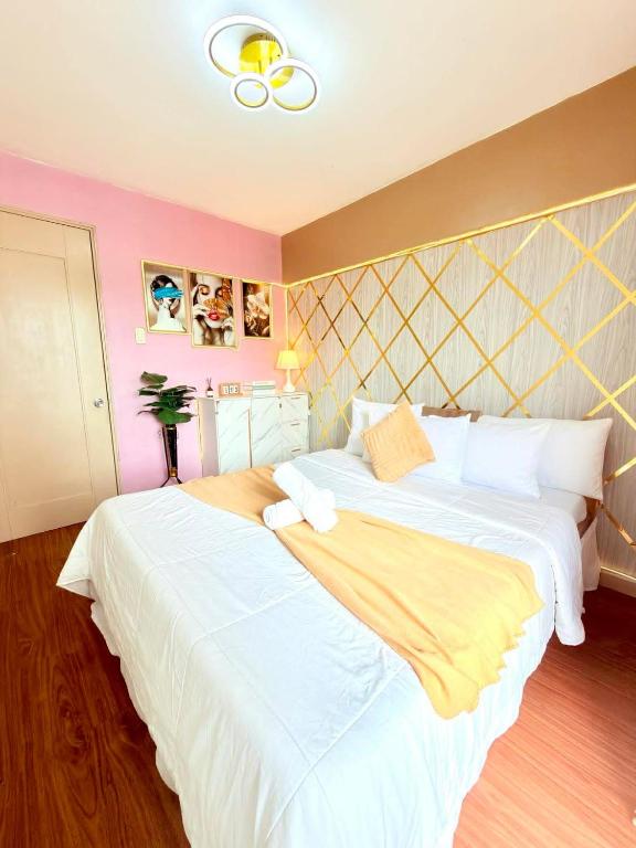 a bedroom with two beds with white and yellow sheets at Relaxing 2BR at Camella Northpoint with balcony pool view 3rd floor in Davao City