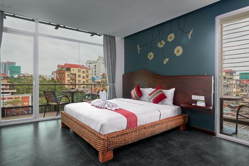 1 dormitorio con 1 cama y vistas a la ciudad en Monsoon Bassac Hotel en Phnom Penh