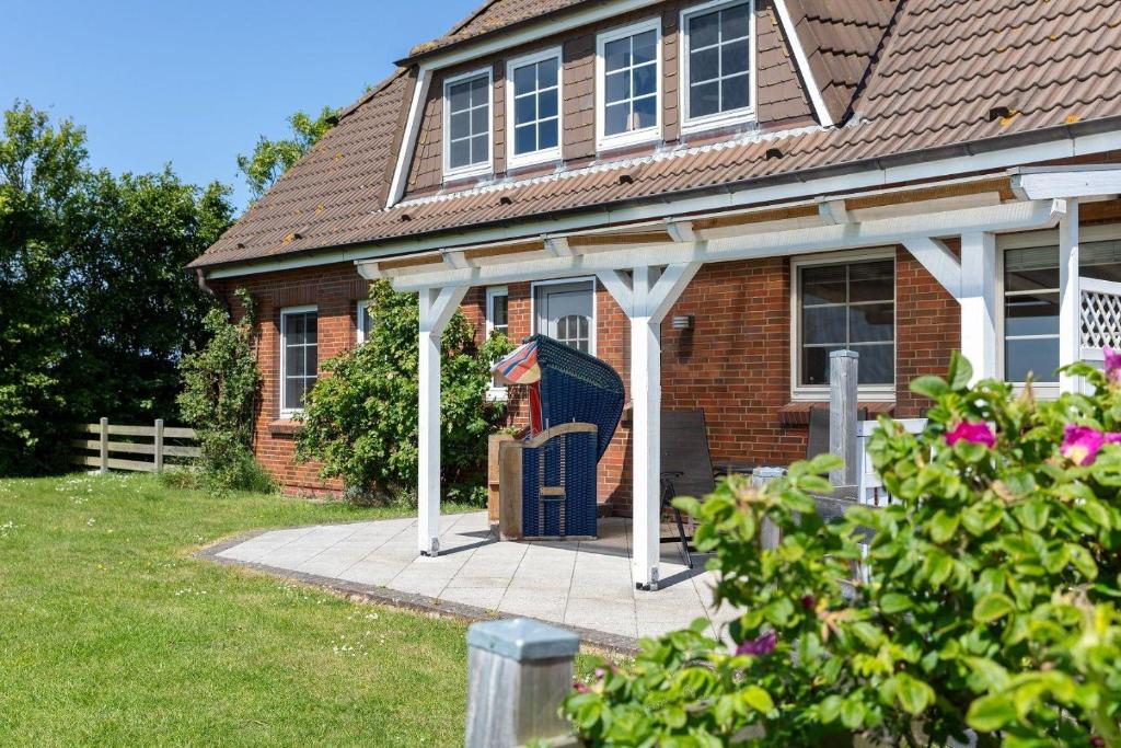 a brick house with a porch with white columns at Hus-Pellworm-1-Ferienwohnung-Meerestraum in Pellworm