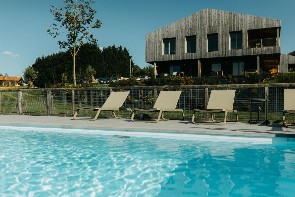a group of lounge chairs next to a swimming pool at Basoan in Mungia