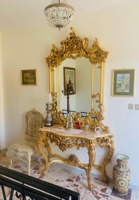 a gold dressing table with a mirror and a chair at Casa Abenante in Corigliano Calabro
