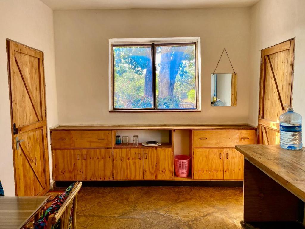 a room with a window and a counter with a table at HIGSAM apartment in Ukunda