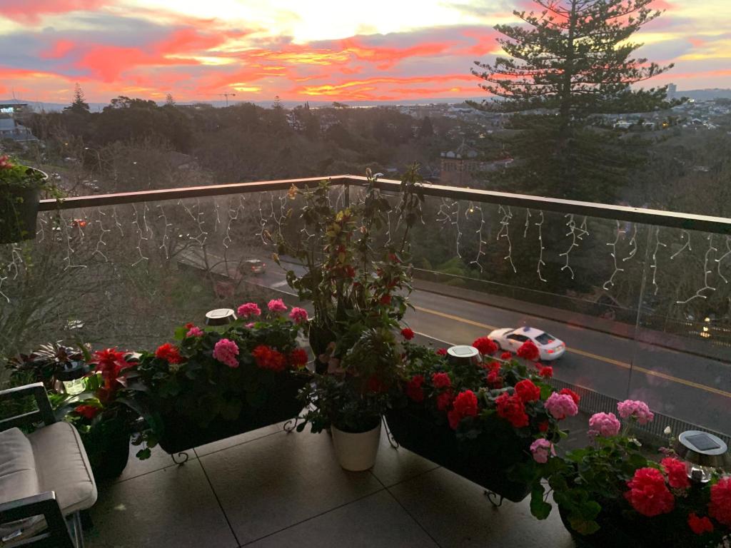 a balcony with flowers and a view of a road at Urba Residences in Auckland