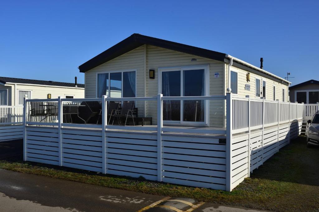 a tiny house with a porch and a fence at Shrimp Shack in Heysham