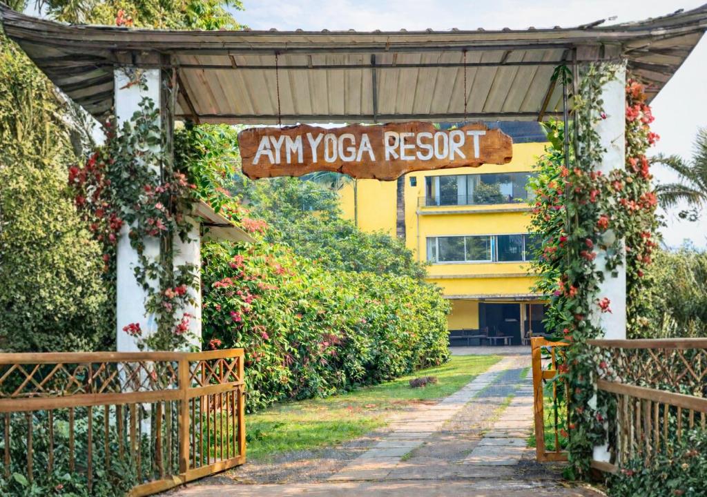 an entrance to an ivy covered resort with a gate at AYM Yoga Resort Arambol GOA in Arambol