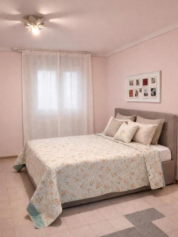 a bedroom with a large bed with a window at Casa Rosa - monolocale con giardino e posto auto in Levanto