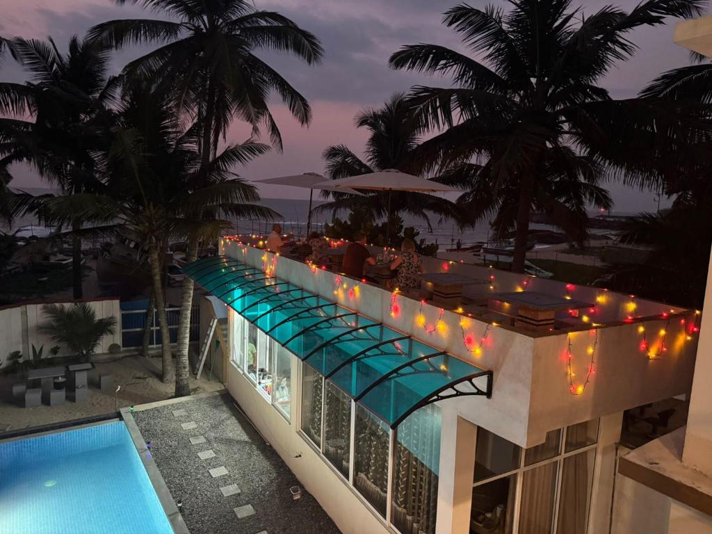 a view of a building with a pool and lights at Danish Crown Hotel in Ambalangoda