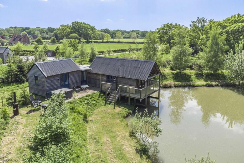 an aerial view of a cabin next to a lake at The Boathouse in Biddenden