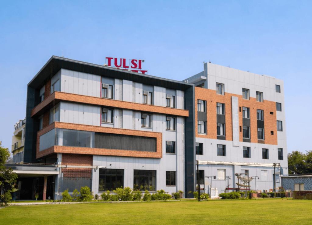 a building with a hotel sign on top of it at Tulsi Resort in Gorakhpur
