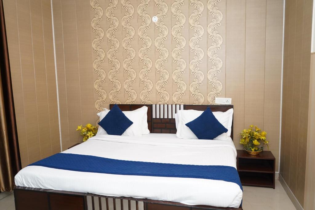 a bedroom with a bed with blue and white pillows at Hotel The Bliss Near Housing Board Chowk Mani Majra Chandigarh in Chandīgarh
