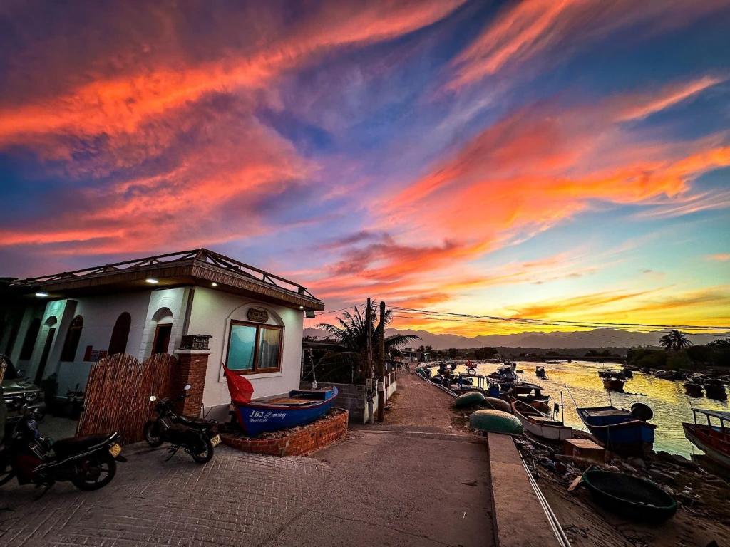 a sunset with boats in the water and a building at Homestay JB Sơn Hải in Thôn Sơn Hải