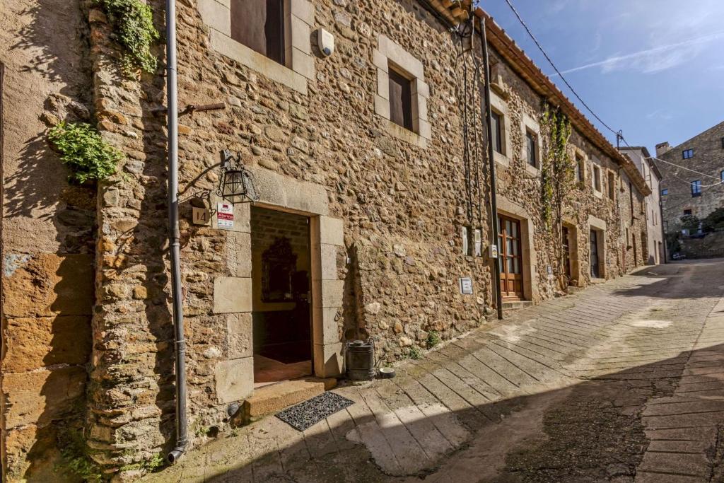 a stone building with a door on a street at Balco de l' Empordà in Corçà