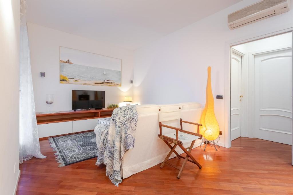a living room with a television and a chair at Hostdomus - Salsedine Apartment in Alassio
