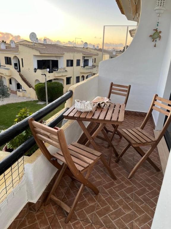 a wooden table and two chairs on a balcony at Casa das Oliveirinhas in Alvor