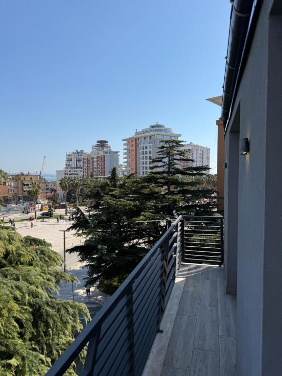 a balcony of a building with a tree and buildings at Hotel Apart Odeon in Durrës