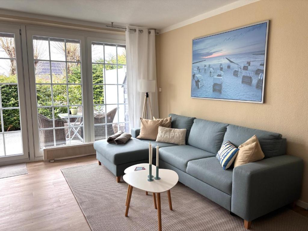 a living room with a blue couch and a table at Ferienwohnung MEERWEH in Fehmarn