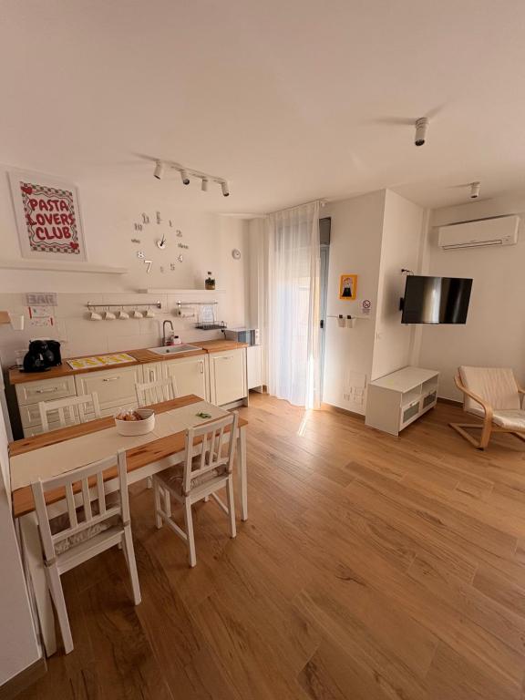 a living room with a table and a kitchen at Solaria House in Montesilvano