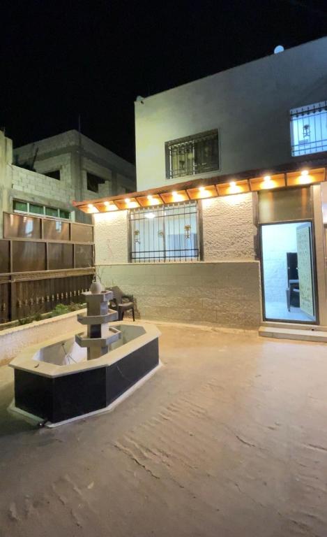 a building with a fountain in front of it at night at درة عبين الجناح الخاص in ‘Ibbīn