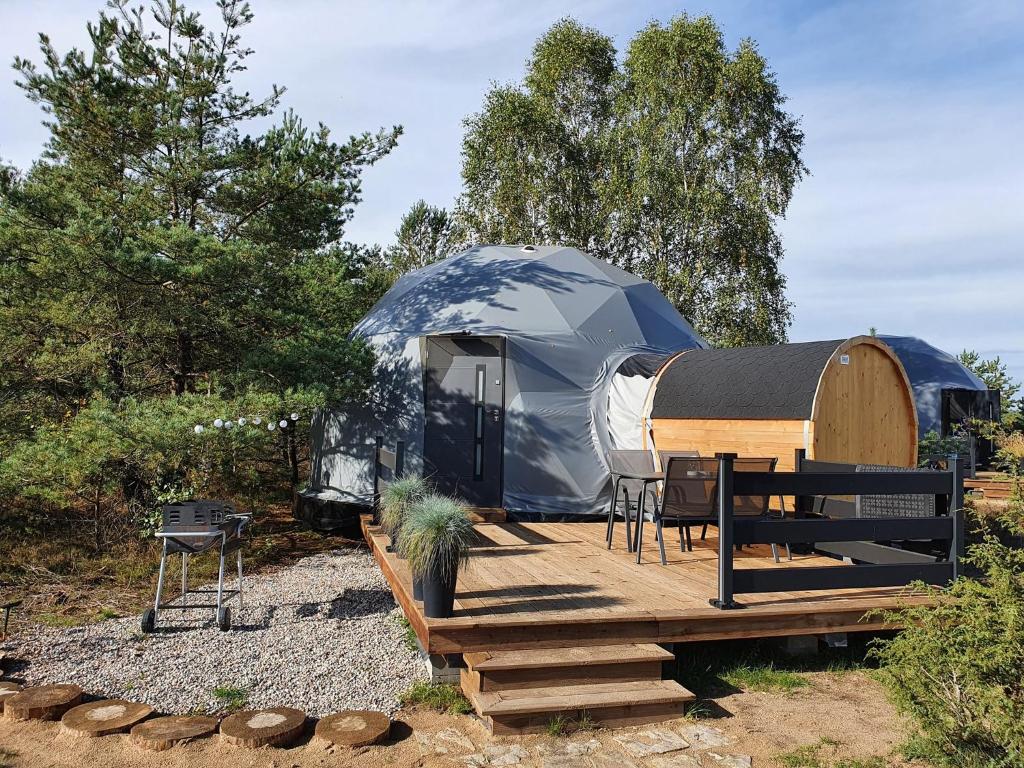 a yurt with a table and chairs on a wooden deck at Glamping Podniebny in Borsk
