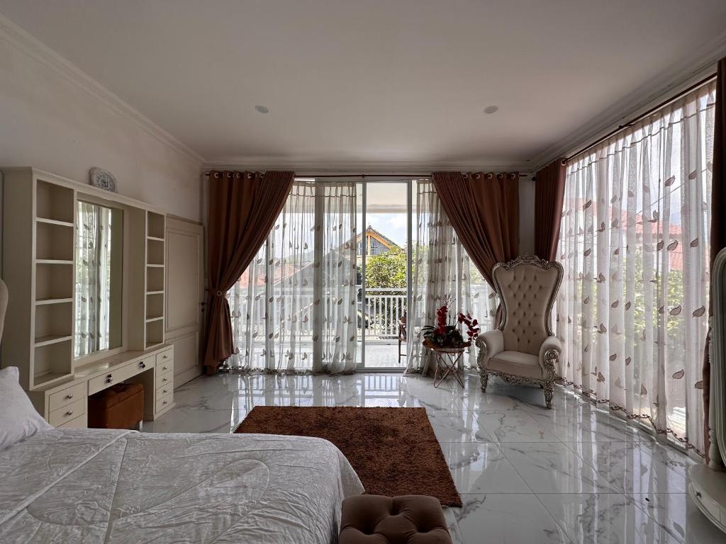 a bedroom with a bed and large windows at RBD Guest House in Ungaran
